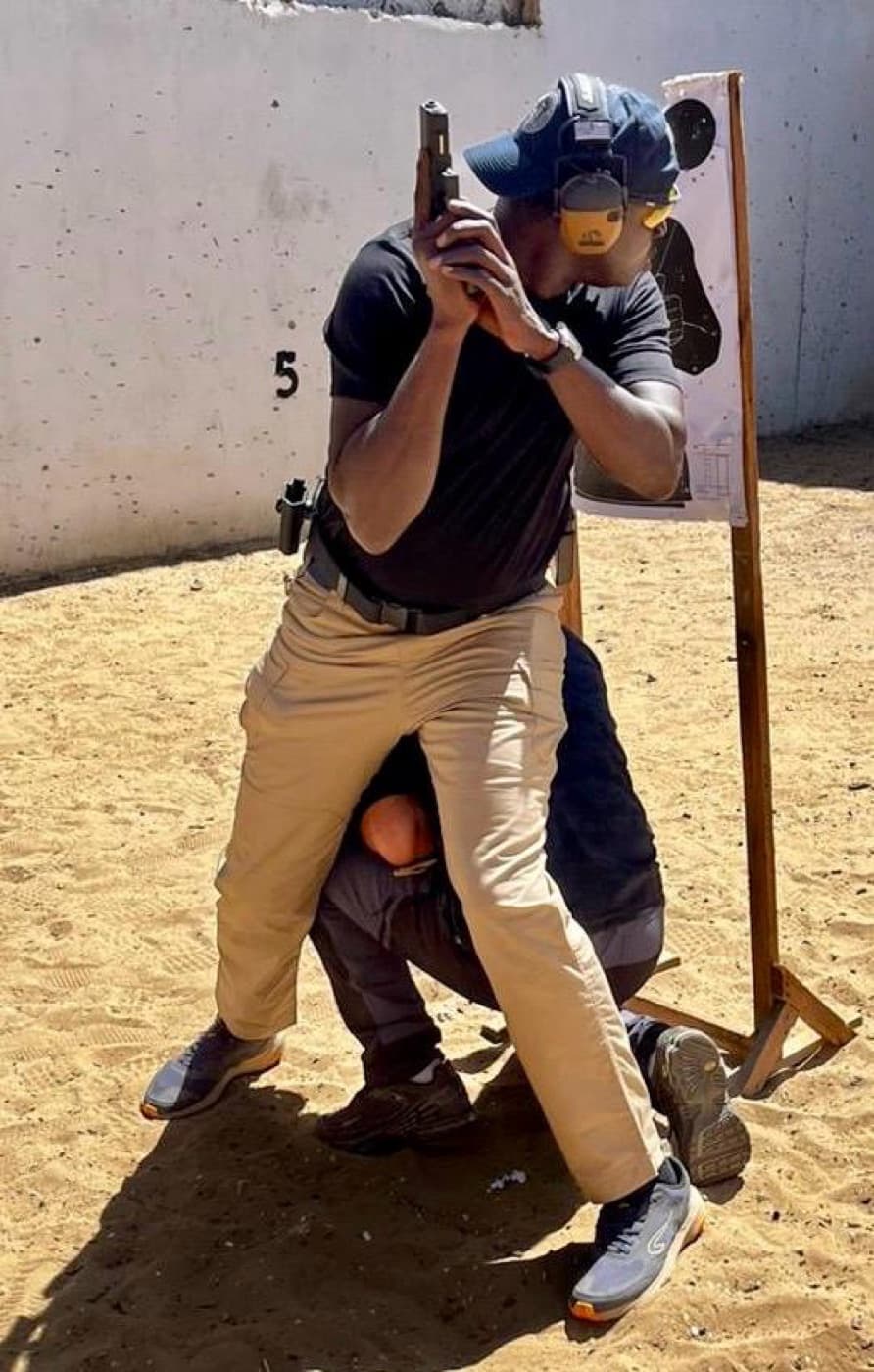 Exercice de protection rapprochée : l'agent couvre le protégé au stand de tir