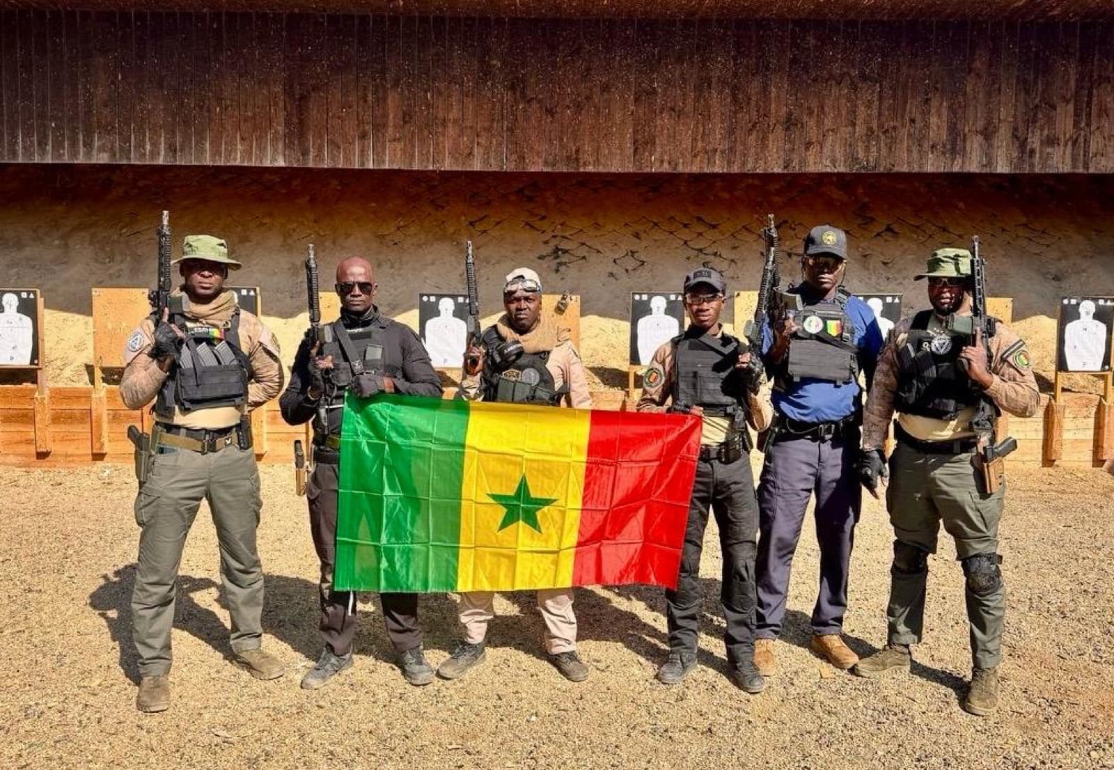 Six opérateurs FIIT réunis autour du drapeau du Sénégal après un stage de tir